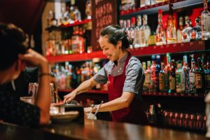 bartender in apron serving drinks