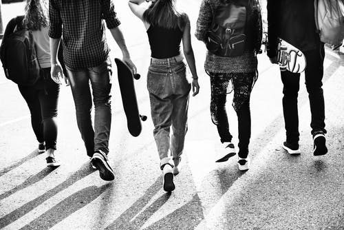 black and white image of group of teens walking