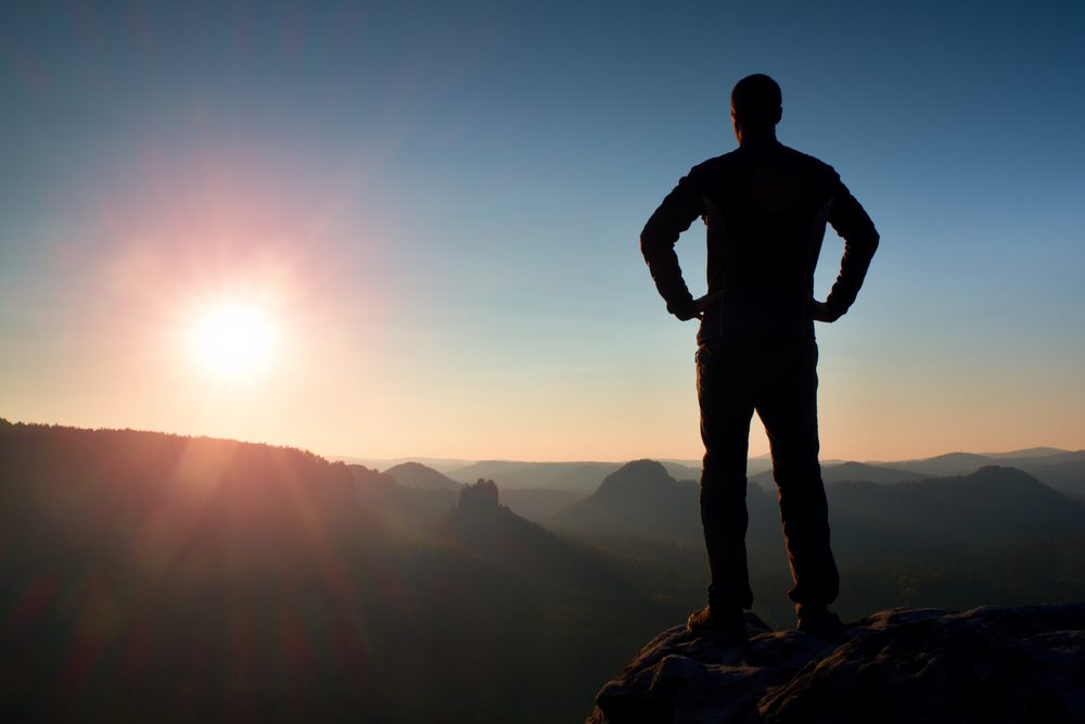 silhouette of man standing on mountain