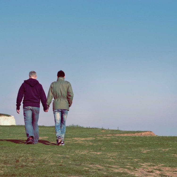 couple holding hands and walking outdoors