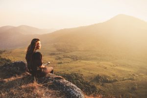 girl sitting on hill during sunset