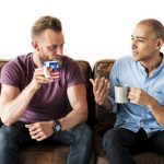 two men talking on couch