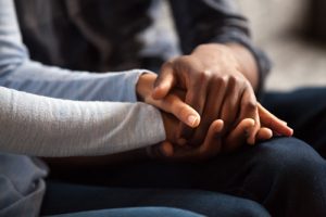 closeup of Black couple holding hands - suicide and addiction