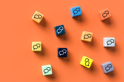 colorful cubes with conversation bubbles on them lying on a bright orange background - drug use