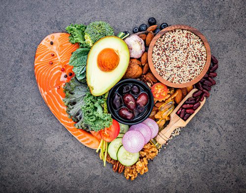 nutrient dense foods like salmon, avocado, kale, and others formed into the shape of a heart
