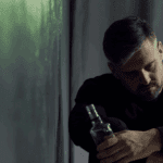 A man holding a bottle of alcohol.